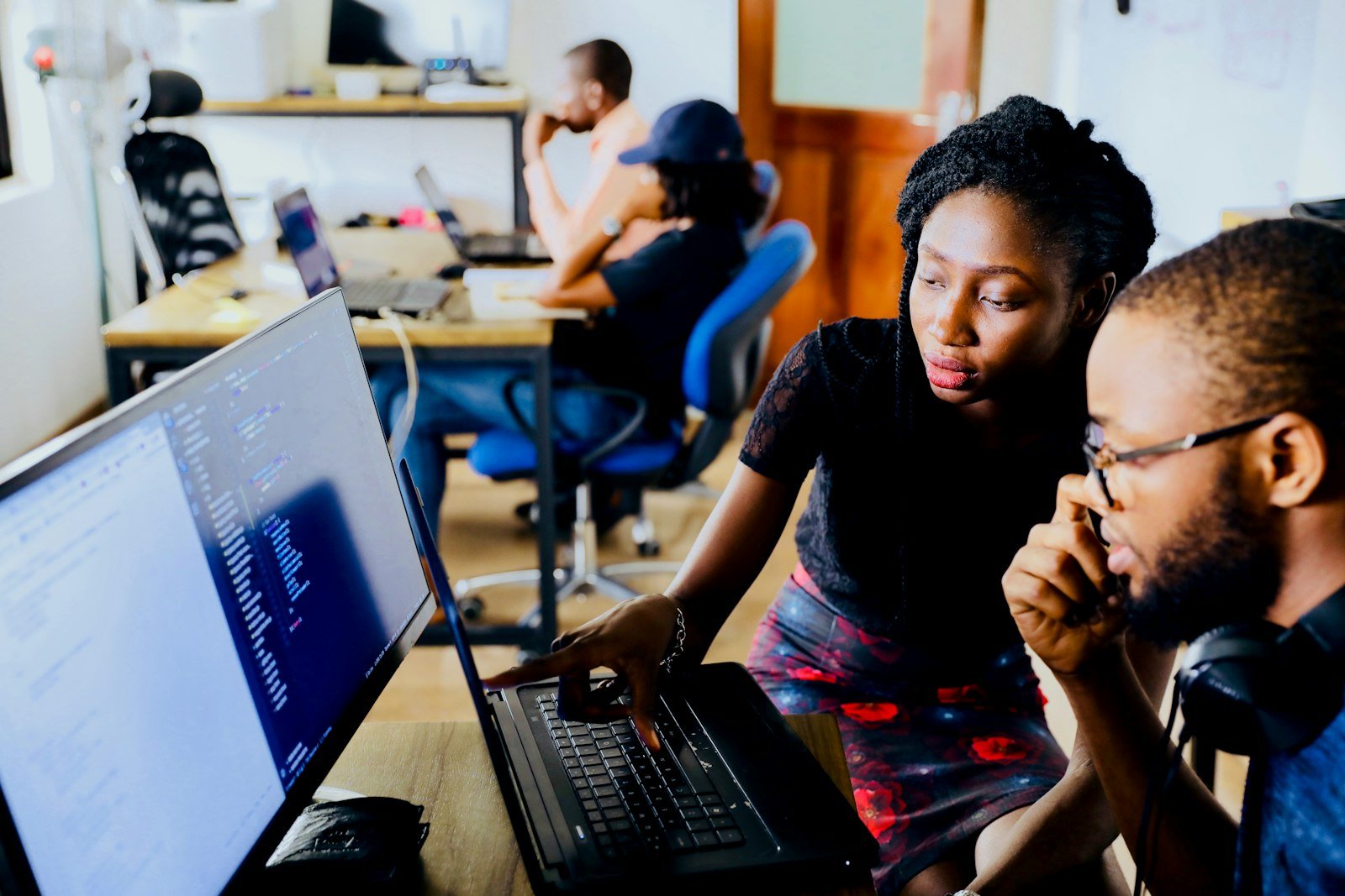 Young African developers collaborating at computers in a tech hub